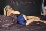 Sexy SANDRA wearing only a very hot blue shiny nylon shorts playing with a bed cloth and posing on a sofa (Pics)