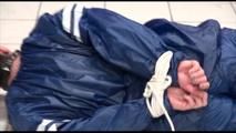 Jill tied and gagged on the floor in an old cellar wearing a shiny blue PVC sauna suit (Video)