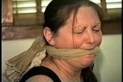 46 Yr OLD REAL ESTATE AGENT'S IS MOUTH STUFFED, CLEAVE GAGGED,  HANDGAGGED, TAPE TIED, WEARING NYLON STOCKINGS, WHITE PANTIES AND IS TIGHTLY HOG-TIED WITH ROPE ON MASSAGE TABLE (D69-6)