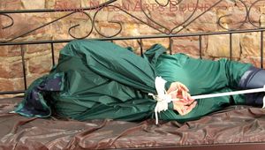 Pia tied, gagged and hooded in a princess bed wearing sexy shiny green rainwear (Pics)