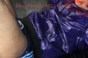 Watching sexy Pia wearing a sexy blue oldschool shiny nylon shorts and a rain jacket being tied and gagged on hands and feet on the ceiling lying on the floor (Pics)