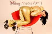 Stella wearing a supersexy golden shiny nylon rainwear combination while lolling on a clubchair (Pics)