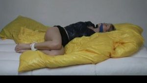 Samantha tied and gagged on a sofa wearing a shiny black nylon shorts and a shiny rain jacket (Video)