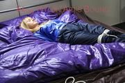 Samantha tied and gagged on bed wearing a shiny darkblue nylon rain pants and a light blue rain jacket (Pics)