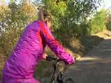 Watch Sandra riding her Bike in her sexy pink shiny nylon Rainsuit