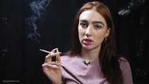 Redhead lady is smoking two cigarettes in the studio
