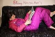 Watching sexy Mara lying on a black shiny sofa wearing a sexy pink downsuit reading a book (Pics)