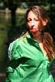 Stella tied and gagged outdoor wearing a shiny green nylon shorts, a shiny green rain jacket and green rubber boots (Pics)