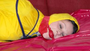 Lucy wearing a supersexy yellow oldschool rainwear coombination tied and gagged with rope and ballgag on a sofa (Pics)