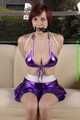 Danny bound in a shiny purple Skirt and Bra, gagged with a Silkscarf