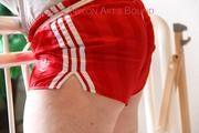 Jill tied and gagged standing on a stairway wearing a sexy red adidas shiny nylon shorts and a top (Pics)