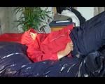 Sonja posing and lolling on bed wearing a sexy blue/red rainwear combination (Video)