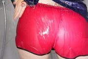 Jill wearing a sexy red shiny nylon shorts and a black rain jacket in the shower having fun with the water and clothes (Pics)