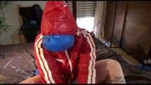 Jill tied, gagged and double hooded on a bar wearing a sexy shiny nylon shorts and two rain jackets (Video)