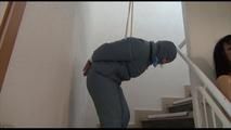Jill tied, gagged and hooded in an stairway wearing a sexy shiny grey downwear (Video)