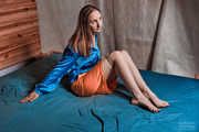 Jute tied legs in shiny blue blouse and orange skirt