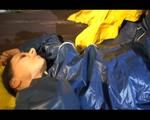 Lucy playing with zipper and lolling on a bed wearing supersexy blue AGU rainwear (Video)