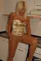 Martina posiert in ihrer goldenen Corsage, schwarzen Leggins, Strumpfhose und Heels in der Küche