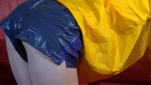 Sonja preparing her sofa with a special shiny nylon cloth wearing a supersexy selfmade shiny nylon shorts in darkblue/purple and a yellow rain jacket (Video)