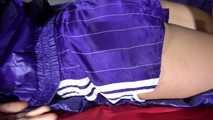 Sandra preparing her shiny nylon bed wearing sexy purple shiny nylon shorts and a purple shiny nylon rain jacket (Video)