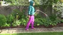 Watching Sandra taking a sun bath and watering the garden the pest plants wearing a sexy purple rain pants and a green down jacket (Video)