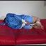 Sonja tied and gagged with ropes and a clothgag on a sofa wearing a sexy lightblue shiny nylon shorts and a rain jacket (Video)