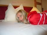 Beautiful archive girl tied and gagged on a bed wearing shiny shorts (Pics)