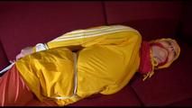 Lucy tied, gagged and hooded on a red sofa wearing a sexy orange shiny nylon pants and a yellow rain jacket (Video)