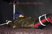 Watching Jill being tied on a bed wearing a shiny nylon rain jacket and a down jacket as well as a rain pants being double hooded and gagged with a ballgag (Pics)