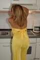 Busty Alexandra posing in a yellow jumbsuit in the kitchen