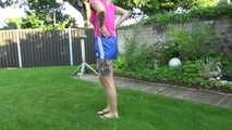 Watch Maly in her shiny nylon Shorts enjoying the warm Weather in the Garden