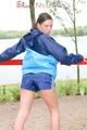 Enni wearing sexy shiny nylon shorts and rain jacket while stretching herself on a sea (Pics)