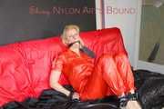 Pia tied and gagged with nack ties on a bed wearing a sexy red shiny nylon rainwear catsuit (Pics)