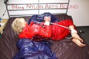 Pia tied and gagged on bed wearing a shiny red rain pants and a shiny red/purple down jacket (Pics)