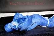LUCY tied, gagged and hooded with ropes and a cloth gag on bed wearing a sexy blue shiny nylon down suit (Pics)
