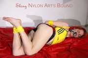 Sonja tied and gagged on a bed wearing sexy black shiny nylon shorts and a yellow top (Pics)