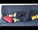 Jill DIamond lolling on a sofa wearing supersexy shiny rainwear (Video)
