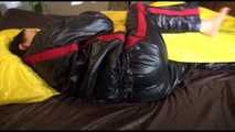 Lucy wearing a sexy black/red shiny nylon downsuit preparing her bed with nylon linen and enjoys it (Video)