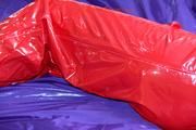 Samantha tied and gagged on bed wearing a shiny red PVC sauna suit (Pics)