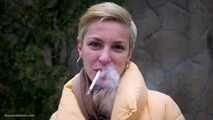 Short cut hair blonde girl is smoking all white 120mm cigarettes