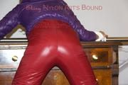 Alina tied and gagged on a commode wearing a shiny red/purple downwear combination (Pics)