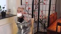 Miss Francine is bound and gagged in a nice short PVC dress covered with a transparent raincoat