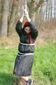 Jill tied, gagged and hooded on a tree outdoor wearing a shiny black down jacket (Pics)