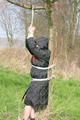 Jill tied, gagged and hooded on a tree outdoor wearing a shiny black down jacket (Pics)