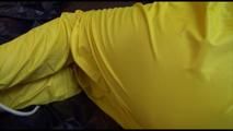Pia tied and gagged on bed wearing a yellow rain pants and an orange downjacket (Video)