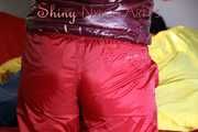 Watching sexy Jill wearing a sexy red shiny nylon rain pants and a red/ purple downjacket lolling in her bed (Pics)