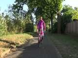 Watch Sandra riding her Bike in her sexy pink shiny nylon Rainsuit