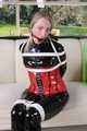 Watch Sophie beeing bound and gagged corsetted in a shiny black PVC catsuit