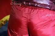 Watching sexy Jill wearing a sexy red shiny nylon rain pants and a red/ purple downjacket lolling in her bed (Pics)