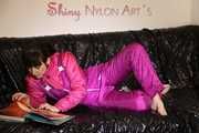 Watching sexy Mara lying on a black shiny sofa wearing a sexy pink downsuit reading a book (Pics)